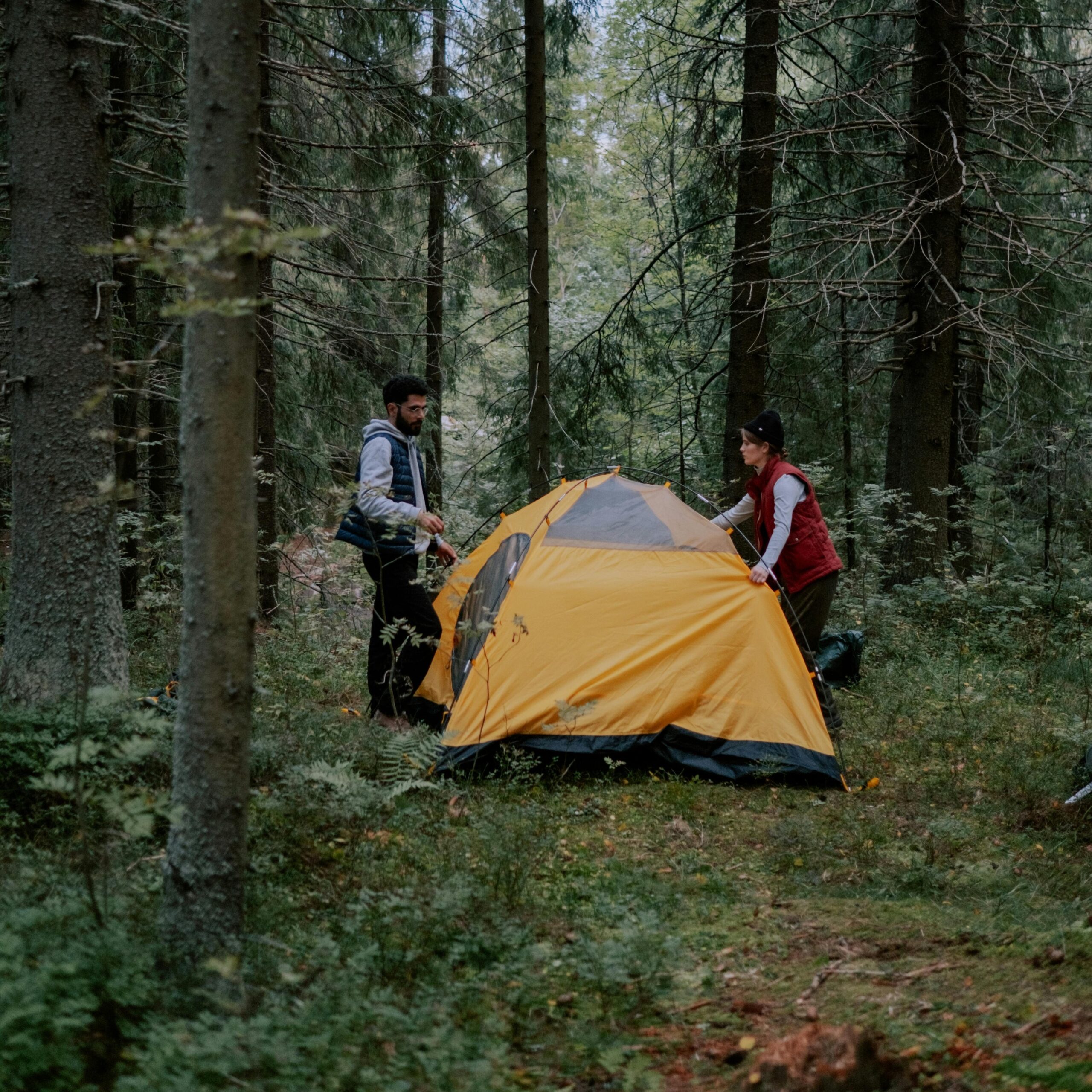 A couple setting up their tent for primitive camping 