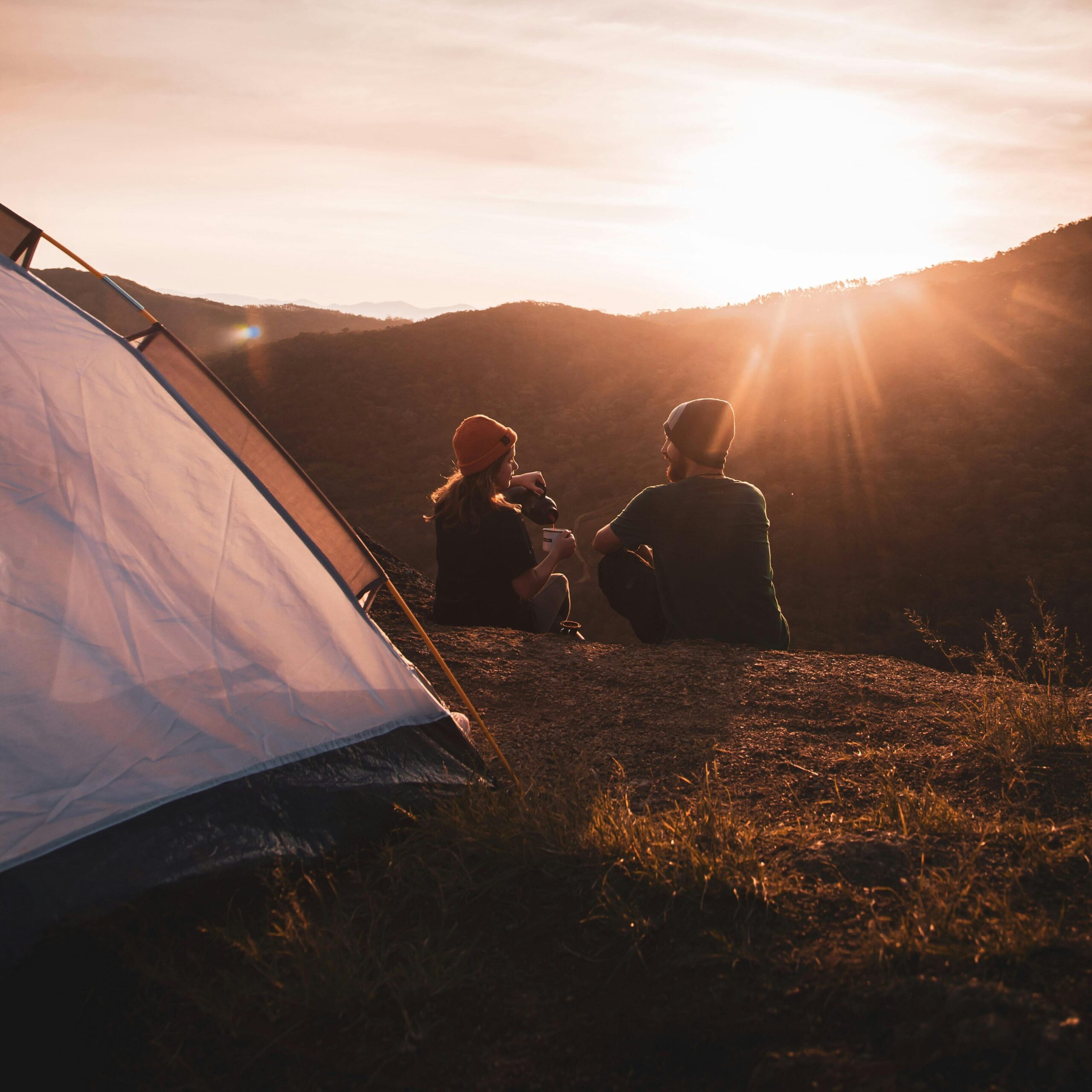 A couple watching the sunrise together while out primitive camping