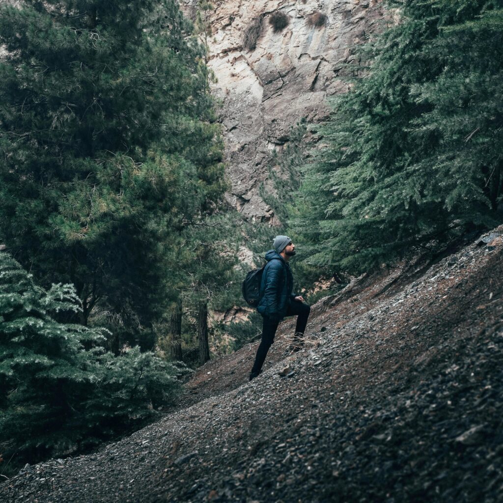 Man climbing an incline while out primitive camping